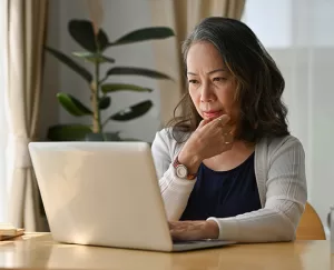 Elderly woman considering information on a laptop