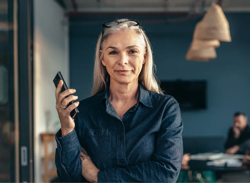 Confident woman holding mobile phone